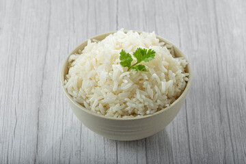 Bowl with cooked rice on the table.
