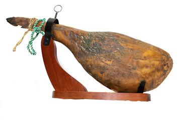 A leg of a Spanish Serrano ham, with a green and white twine, in a ham holder, isolated on white...