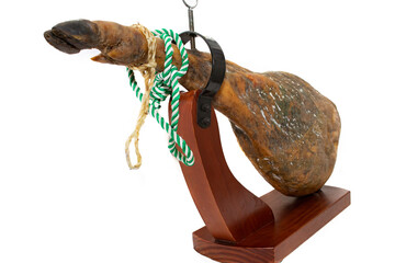 A leg of a Spanish serrano ham, with a green and white string, in a ham holder, in an angular...