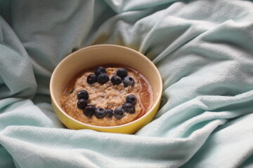 Porridge aux myrtilles et au miel sur un plaid pour un petit-déjeuner sain dès le matin