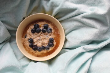 Porridge aux myrtilles et au miel sur un plaid pour un petit-déjeuner sain dès le matin