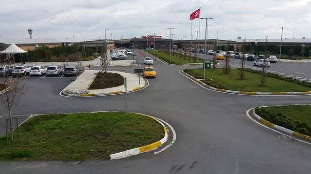 Turkish flag waves near a parking area filled with vehicles and taxis, capturing an everyday urban scene that reflects transportation, national identity, and city life in Turkey.