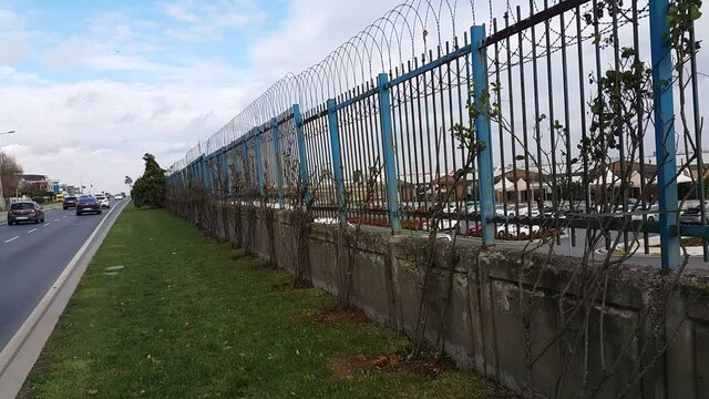 Security fences installed along the roadside form a protective barrier, emphasizing safety, infrastructure, and controlled boundaries within an outdoor urban or highway environment.