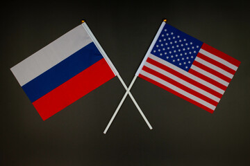 Russia flag and USA flag crossed with each other on the black background. Russia vs USA. Meeting between the presidents of the Russia and United States. Tensions in relations. Isolated. Top view 