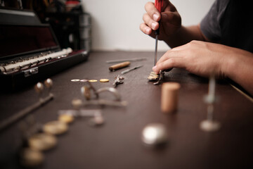 instrument repairman removing old pads from flute keys - obrazy, fototapety, plakaty