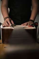 luthier unrecognizable sanding the body of a guitar preparing it for painting