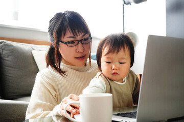子供とノートパソコンを見る女性