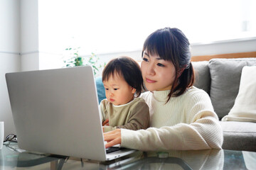 子供とノートパソコンを見る女