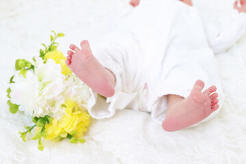 Obraz na płótnie Canvas 赤ちゃんの足と黄色い花