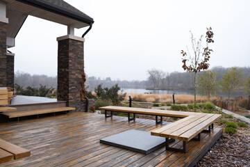 Wooden deck of family home. Terrace on backyard with wooden bench and beautiful view