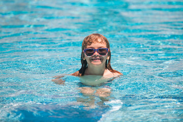 Naklejka premium Kids summer vacation fun. Kid boy swim in swimming pool.