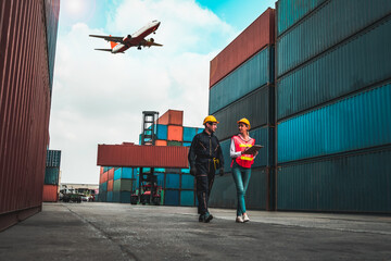 Industrial worker works with co-worker at overseas shipping container port . Logistics supply chain management and international goods export concept . - obrazy, fototapety, plakaty