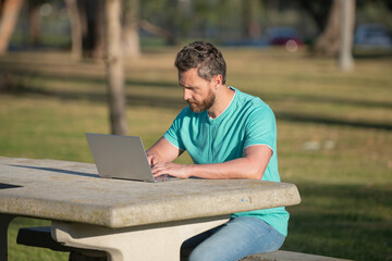 Online learning in nature. Man online work outside.