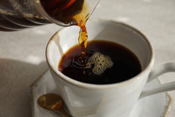 コーヒーを白いカップに注ぐ