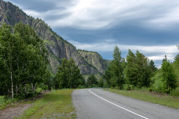 Fototapeta premium asphalt road between mountain peaks. warm summer day