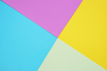 Blank light green paper, purple, yellow, and blue paper in geometric forms form an abstract background concept.