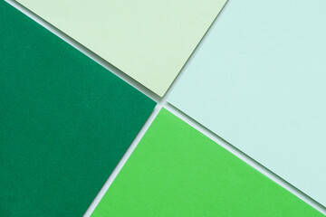 On a white background, an abstract background concept with a geometric composition of blank green paper in various hues.
