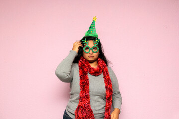 Young fat overweight body positive Latina with Christmas hat shows apathy, anger and displeasure the arrival of December because she does not like to celebrate Christmas
