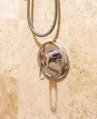 Fototapeten poignée de douche argentée sur mur de pierre beige © Veronique