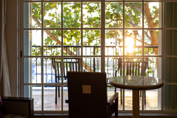 point de vue intérieur sur le soleil levant à travers la fenêtre lors d'un matin ensoleillé avec du mobilier