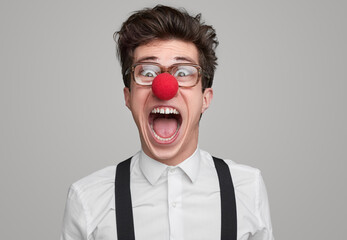 Crazy geek with clown nose screaming at camera