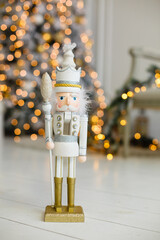 Classic vintage nutcracker on home Christmas room. Wooden toy nutcracker, celebration of Xmas. Retro New Year symbol. Christmas mood in children room. Beige and golden colors in decor