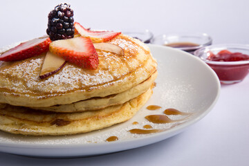 hot cake en fondo blanco con fresas en la parte de arriba 