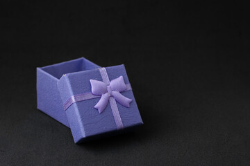blue gift box with an open lid on a black background with copyspace