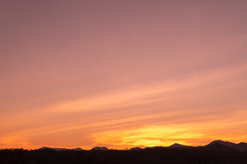 Fototapeta na wymiar The twilight vanilla sky over the silhouette mountains peak