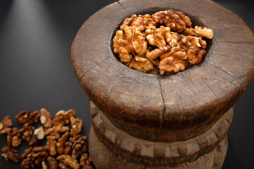 Walnuts in antique, wooden mortar.