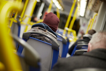 people sitting insite a waggon of a subway tram at winter time