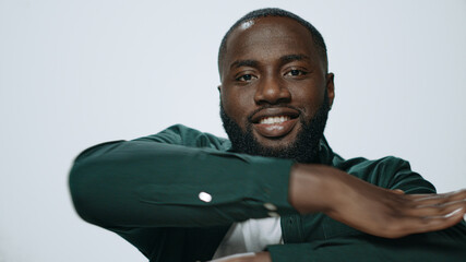 Portrait of bearded african american man dancing on light background. 