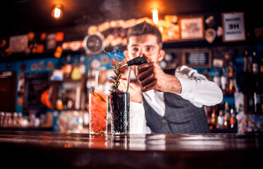 Barman creates a cocktail behind the bar