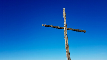 Wooden summit cross with blue sky. Close up, copy space.