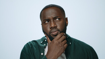 Thoughtful african man thinking indoors. Afro surprised student looking camera 