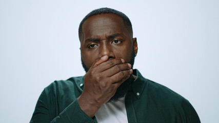 Portrait african man checking breath freshness in studio. Guy preparing for date