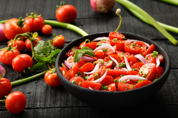 Homemade delicious fresh organic tomato salad with exotic herbs.
