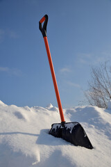 Clearing snow with shovel on sunny winter day