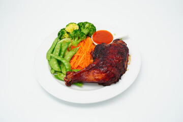 Grilled chicken marinated with spices and boiled fresh vegetables Broccoli, green peas, lettuce in a white plate