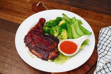 Grilled chicken marinated with spices and boiled fresh vegetables Broccoli, green peas, lettuce in a white plate