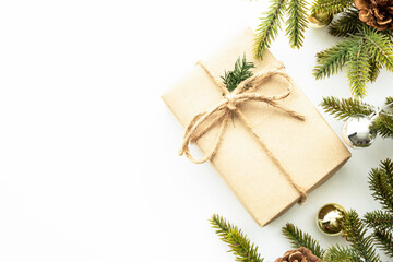Fototapeta na wymiar Beautiful Christmas background with gift box, decorate with pine branches over white background. Top view with copy space, flat lay.
