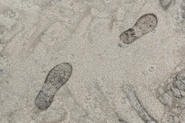 Footprint from the sole of a man's foot shoe against the sand