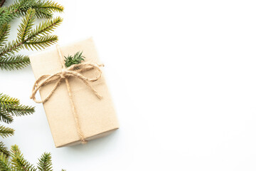 Beautiful Christmas background with gift box, decorate with pine branches over white background. Top view with copy space, flat lay.