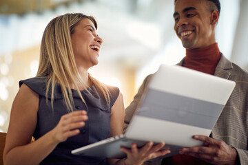 A young businesswoman has good time while watching a laptop content with her young male colleague. Business, people, company
