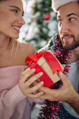 Christmas present for you.Man giving surprise Christmas gift his girlfriend.Christmas present for you.Man giving surprise Christmas gift his girlfriend.Christmas present for you.