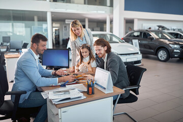 Delighted caucasian family buying a car together