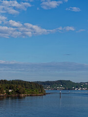 Navigation Markers along the Forested coastline of the Islands and Fjord edge near Bergen in Norway on a Summers Morning.