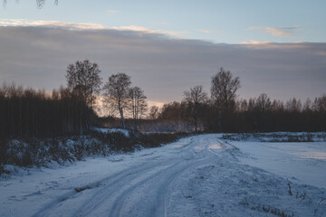 rarely used snow covered never cleaned country roads leads to forest. Wintertime in Latvia at Christmas time