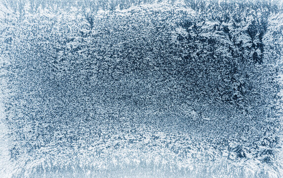 Frost patterns on frozen winter window as a symbol of Christmas wonder. Christmas or New year background. © volff