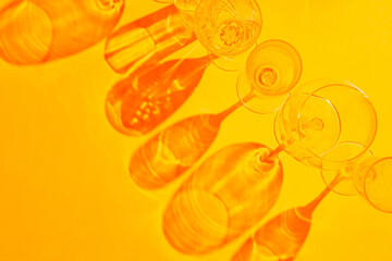 Empty drink glasses with shadows in the sunset light. Glassware with shadows on an orange...